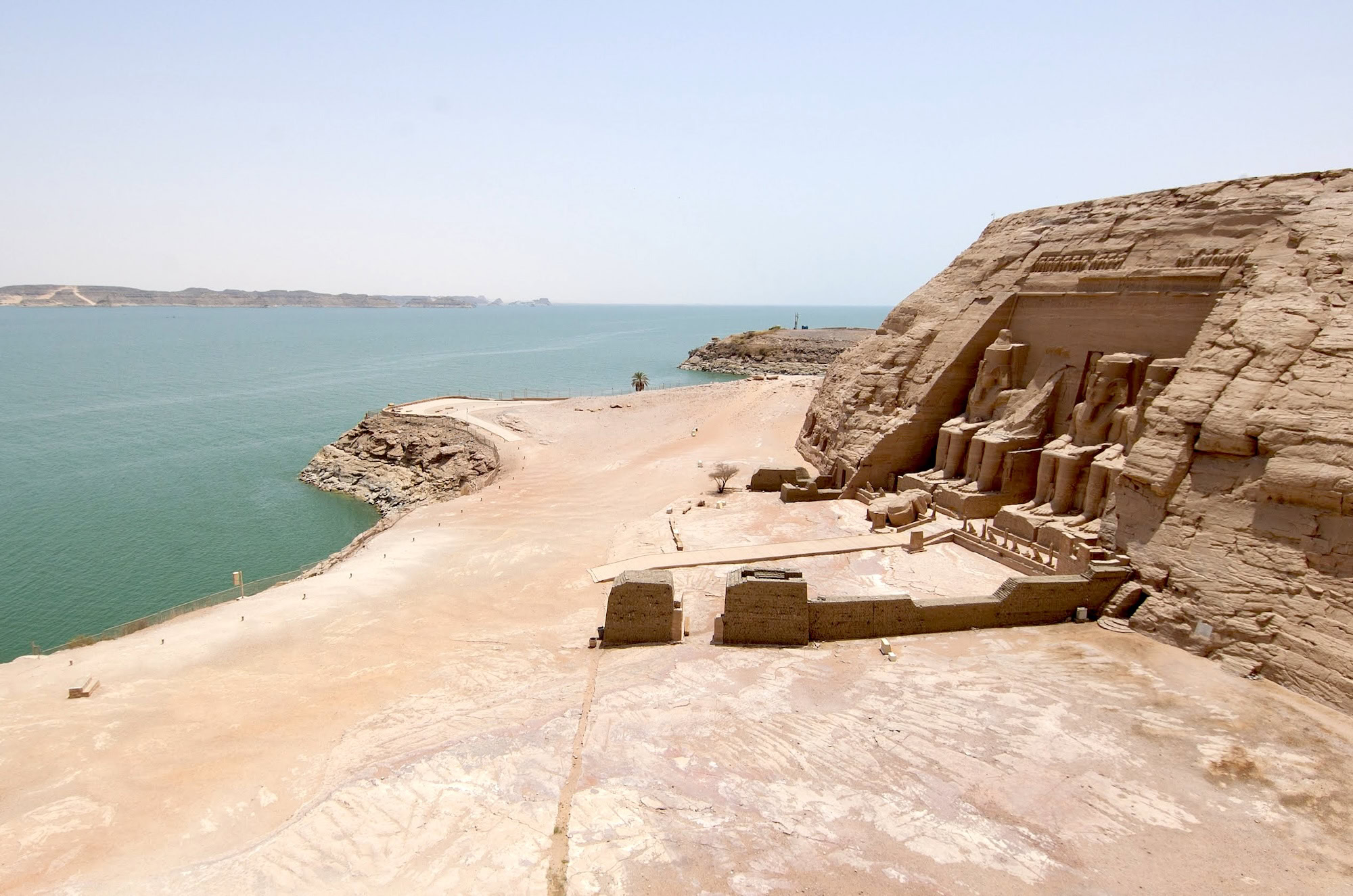 Abu Simbel temple complex with ancient statues and columns beside a lake