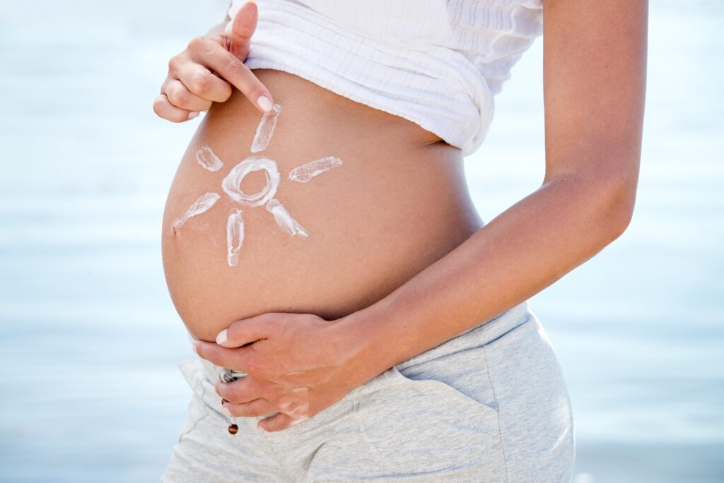 Pregnant sunscreen and a woman on the beach during summer for sun protection