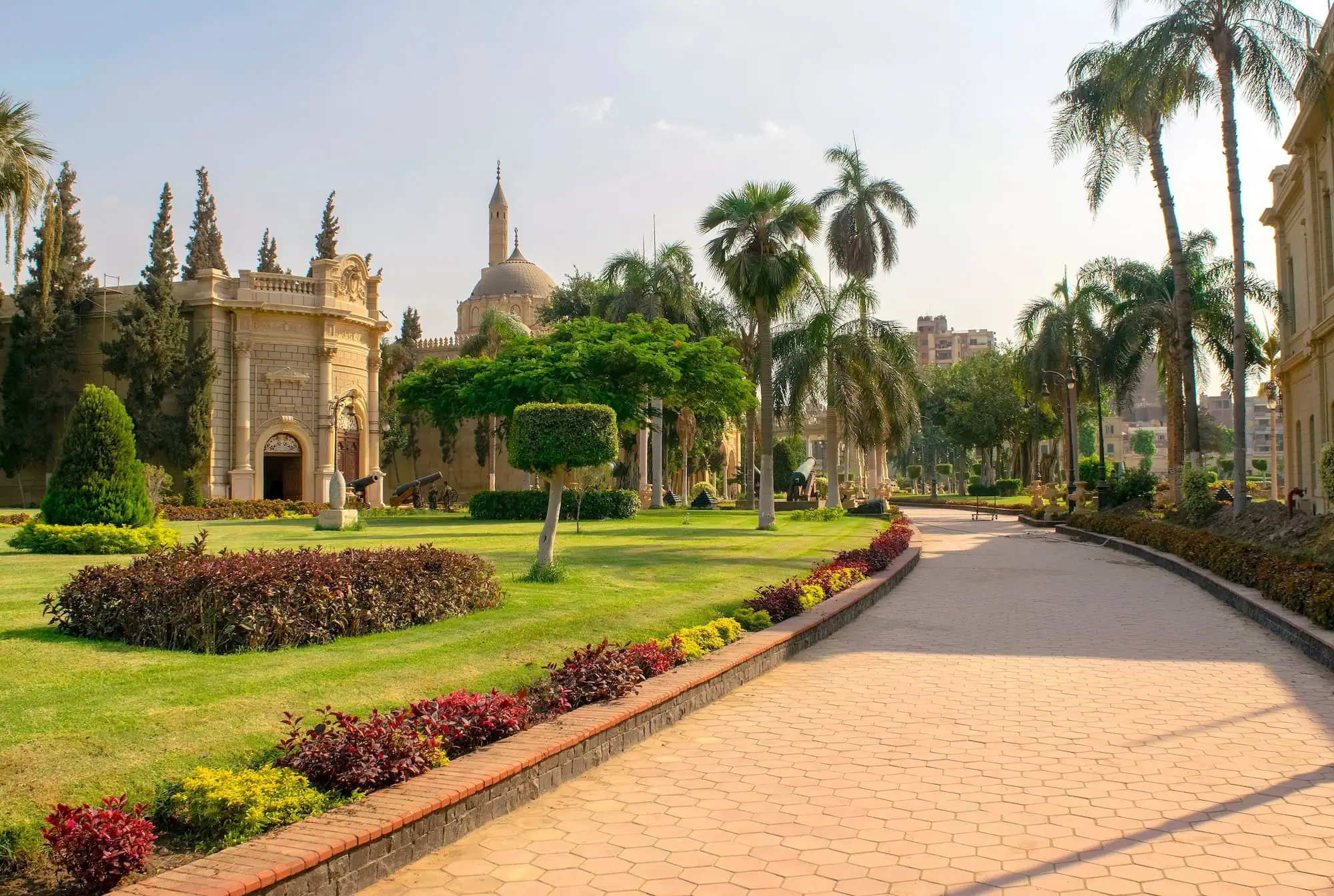 Peaceful mosque with dome and minaret surrounded by palm trees and garden in Islamic Cairo