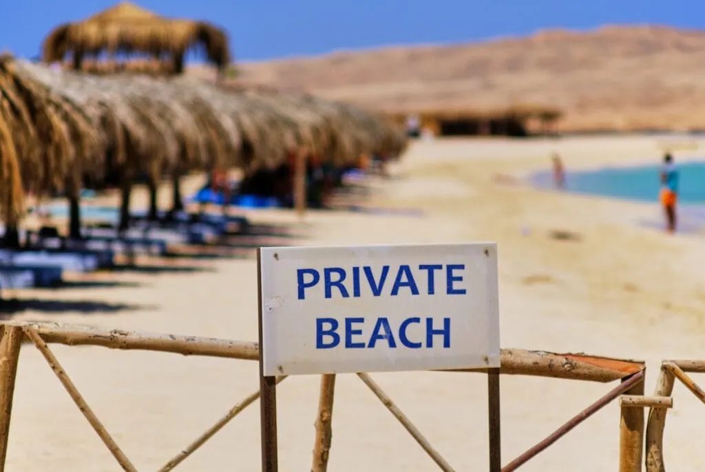 Private Beach sign on white sandy shore with clear waters
