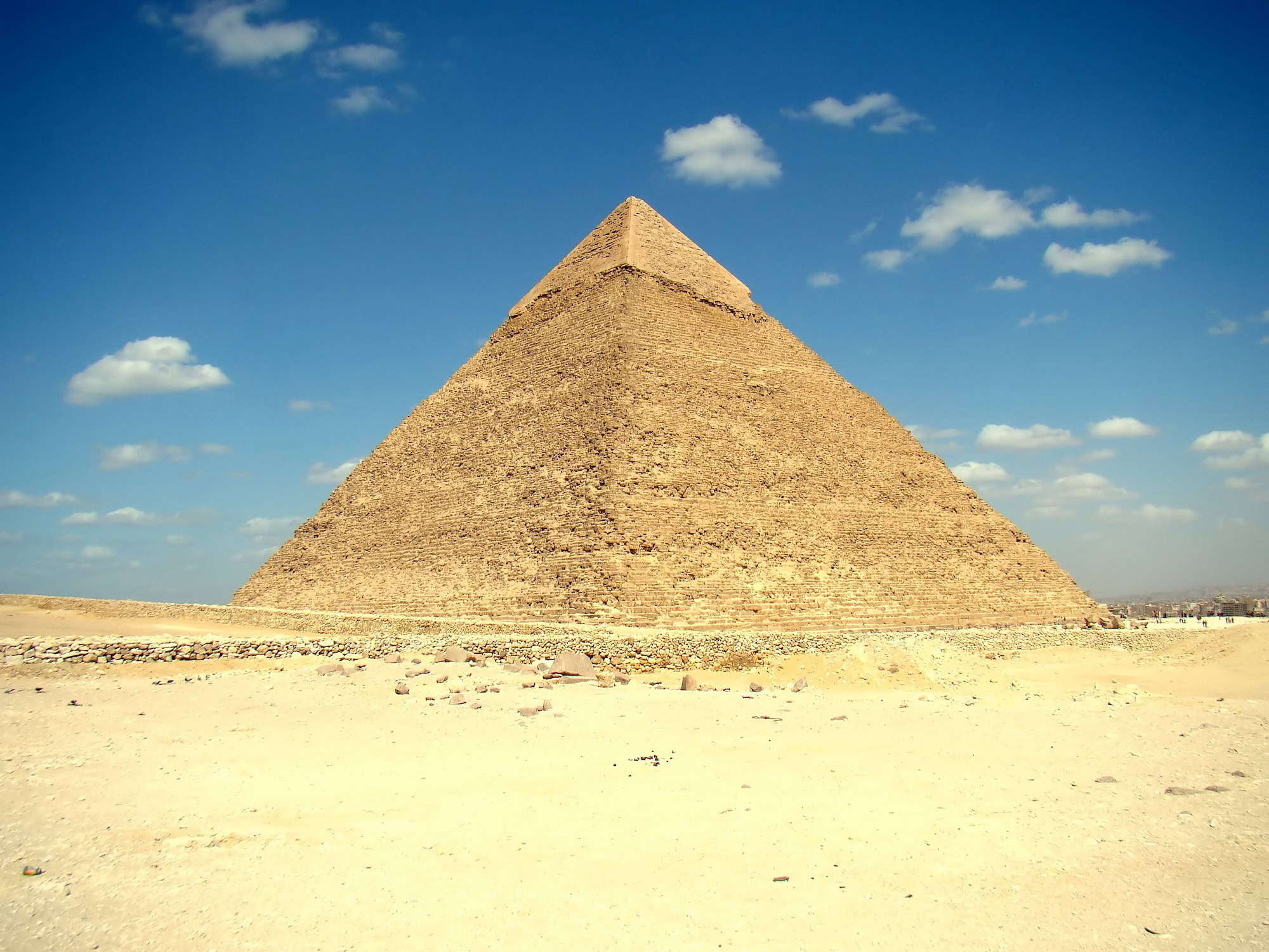 Great Pyramid of Giza standing majestically in desert with few visitors present