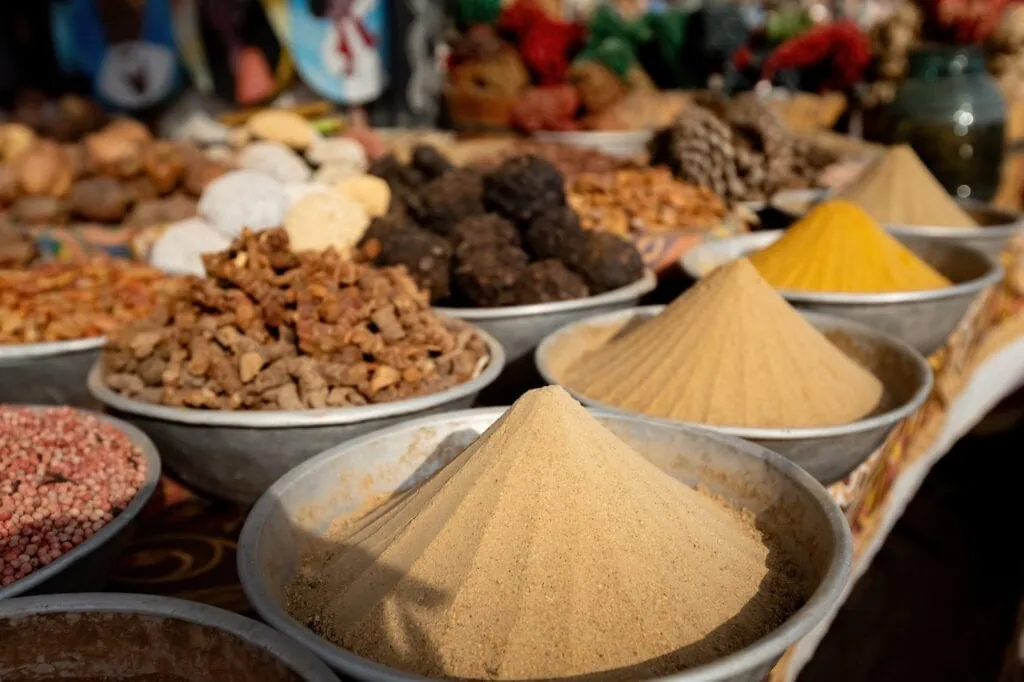 Pyramids of colorful spices and powdered herbs at a traditional Aswan market