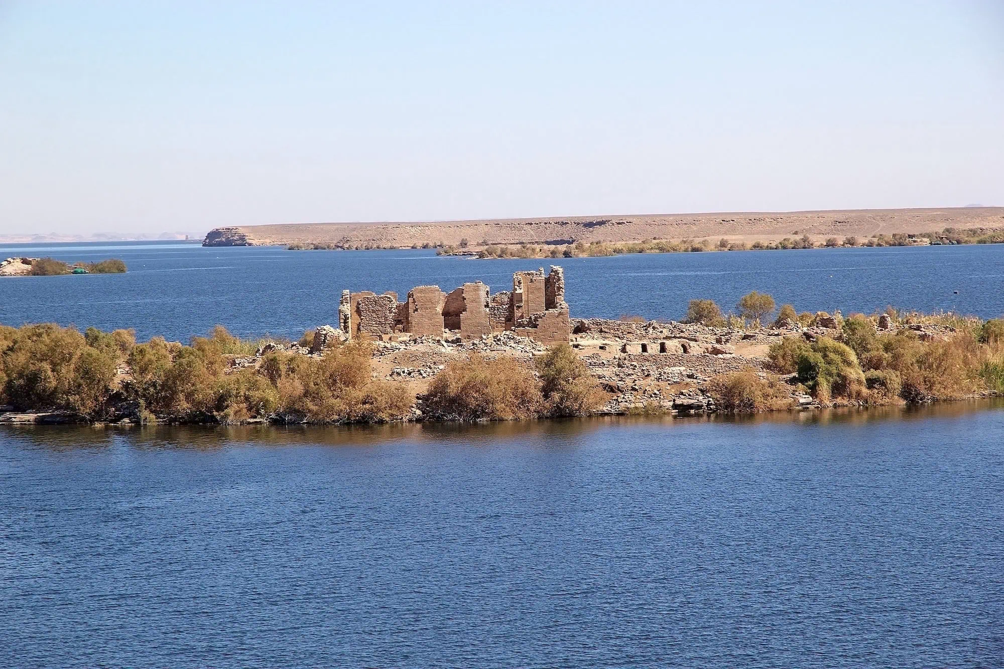 Ancient Kalabsha Temple ruins on peaceful island surrounded by Lake Nasser waters