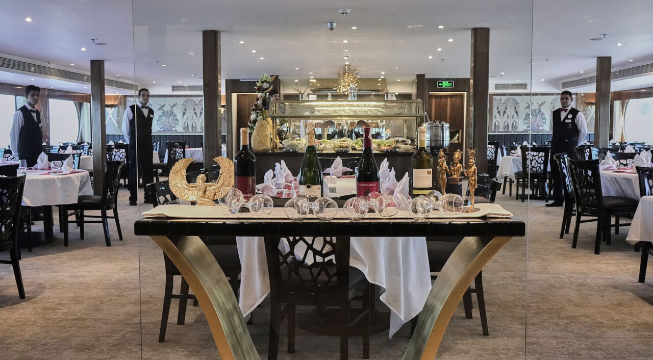 Ristorante elegante a bordo della MS Radamis I con tavoli apparecchiati e illuminazione soffusa