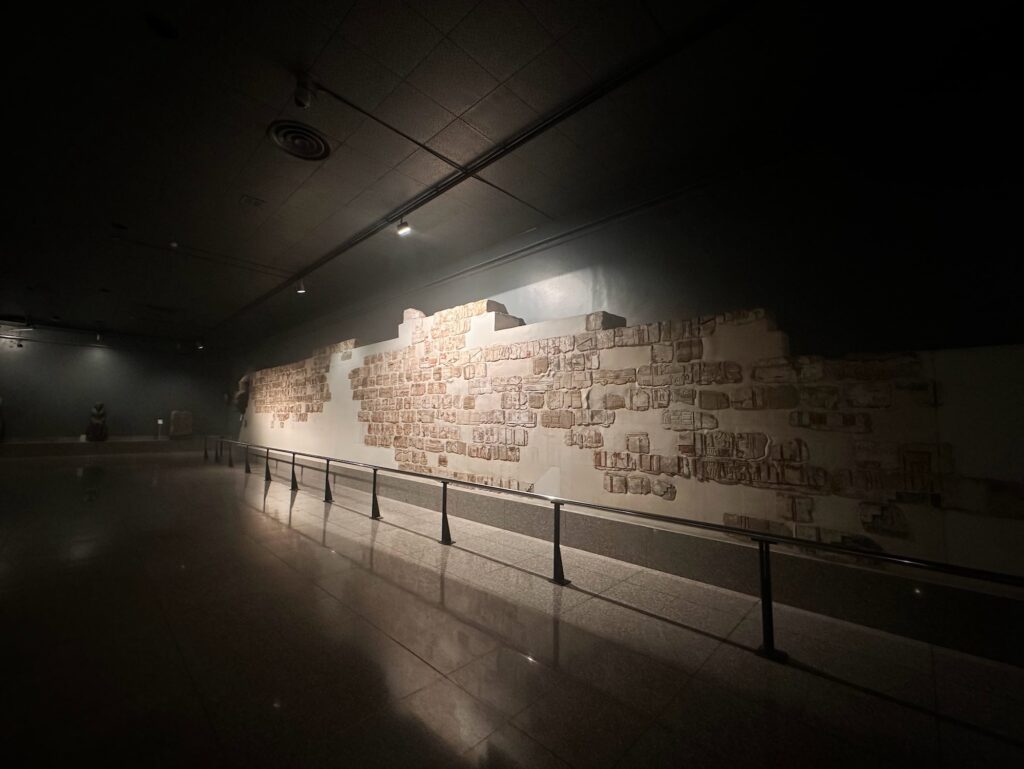 Reassembled stone relief blocks displayed along a gallery wall inside the Luxor Museum, Luxor