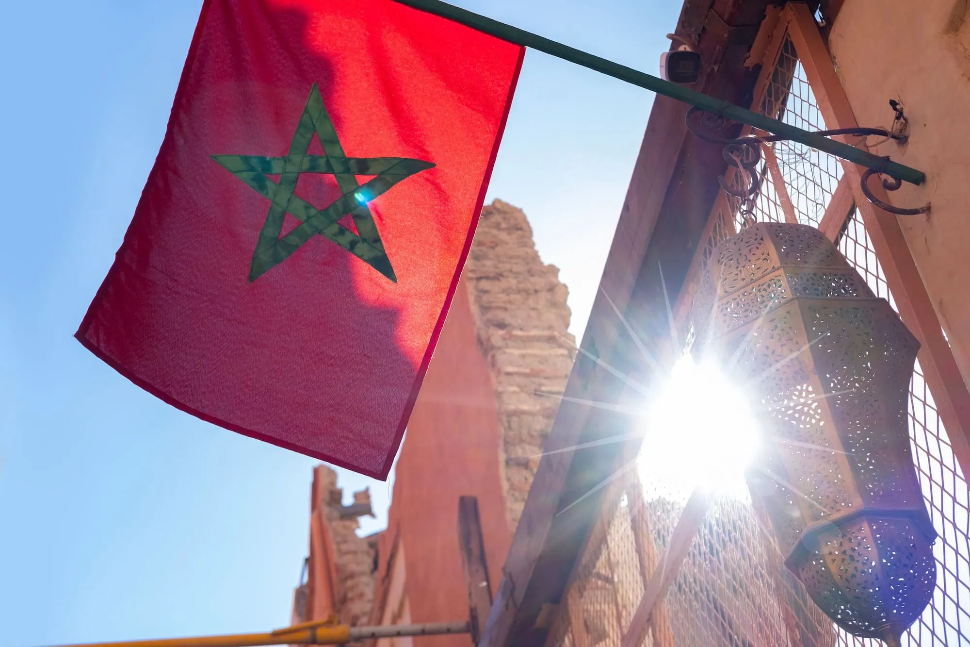 Moroccan flag and traditional lantern in vibrant medina setting with stone architecture