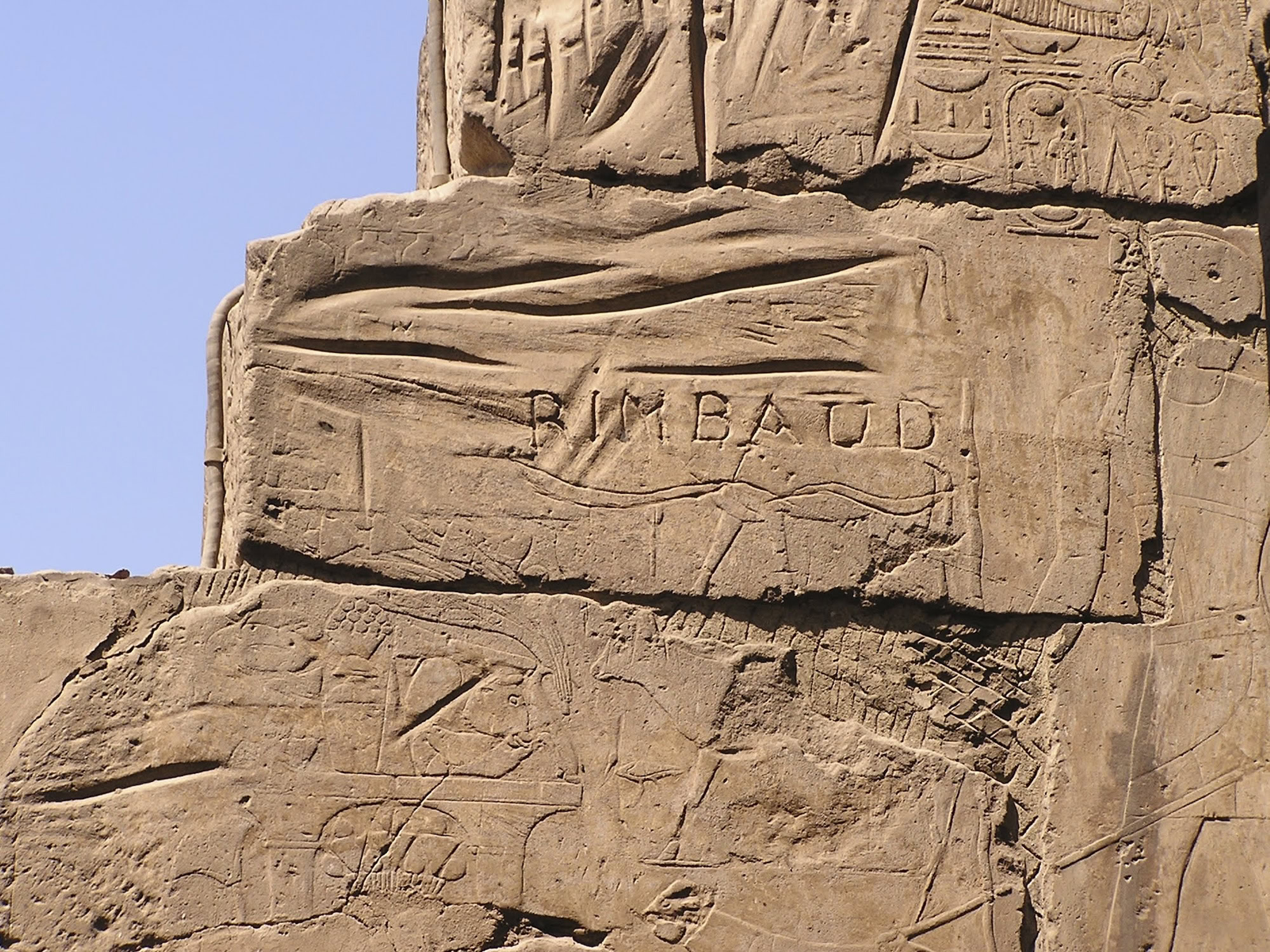 Ancient Egyptian temple ruins with hieroglyphic inscriptions carved in sandstone blocks