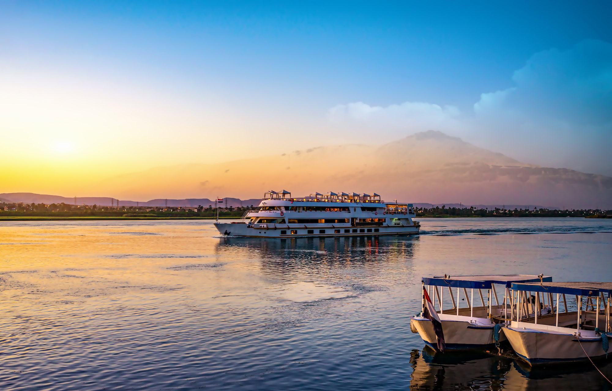 Modern cruise ship on the Nile River with mountains in background