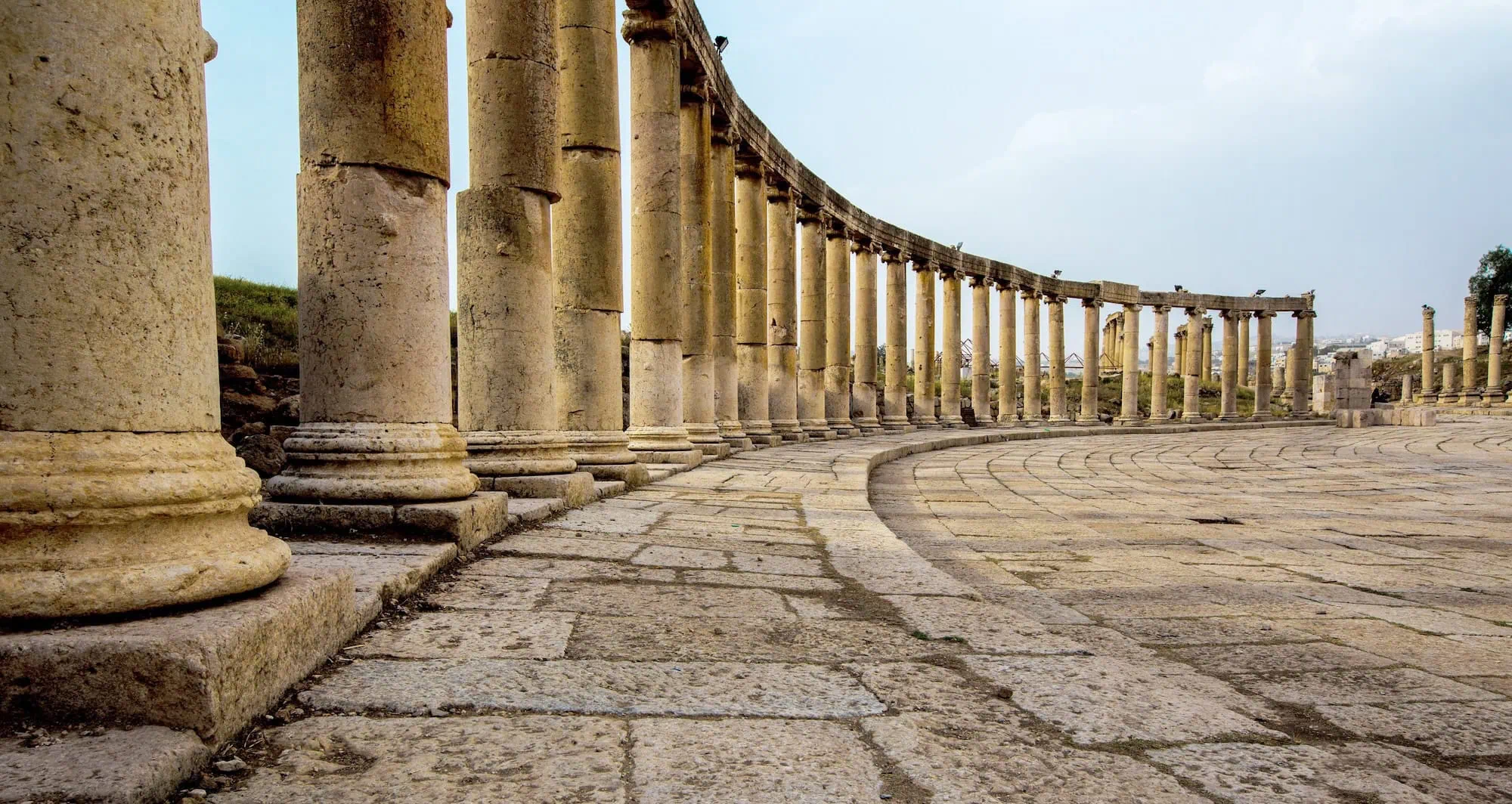 Ancient Roman colonnade with curved arrangement of stone columns at Jerash archaeological site in Jordan