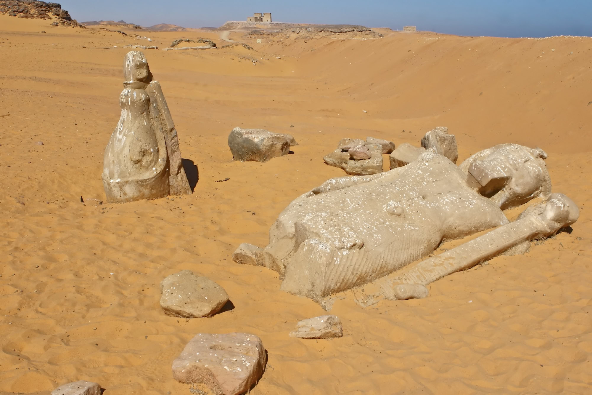 Ancient Egyptian statue with hieroglyphic carvings at archaeological ruins site