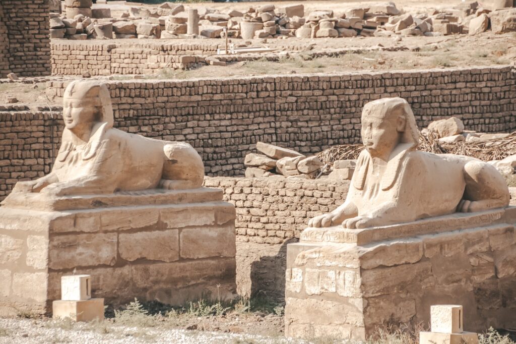 Human-headed sphinx statues lining a stone processional avenue at Karnak Temple, Luxor
