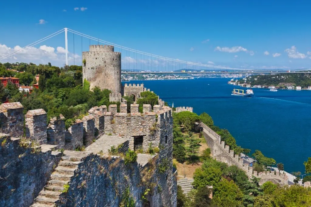 Rumeli Fortress on the European bank of the Bosphorus in Istanbul, Turkey, with the strait and bridge behind it.