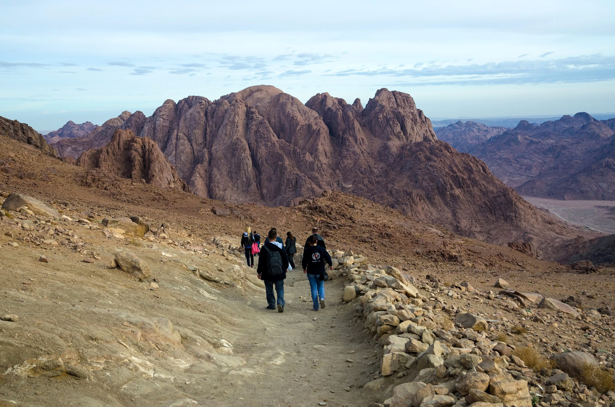 Hikers walking along mountain trail on Mount Sinai in Egypt's desert landscape
