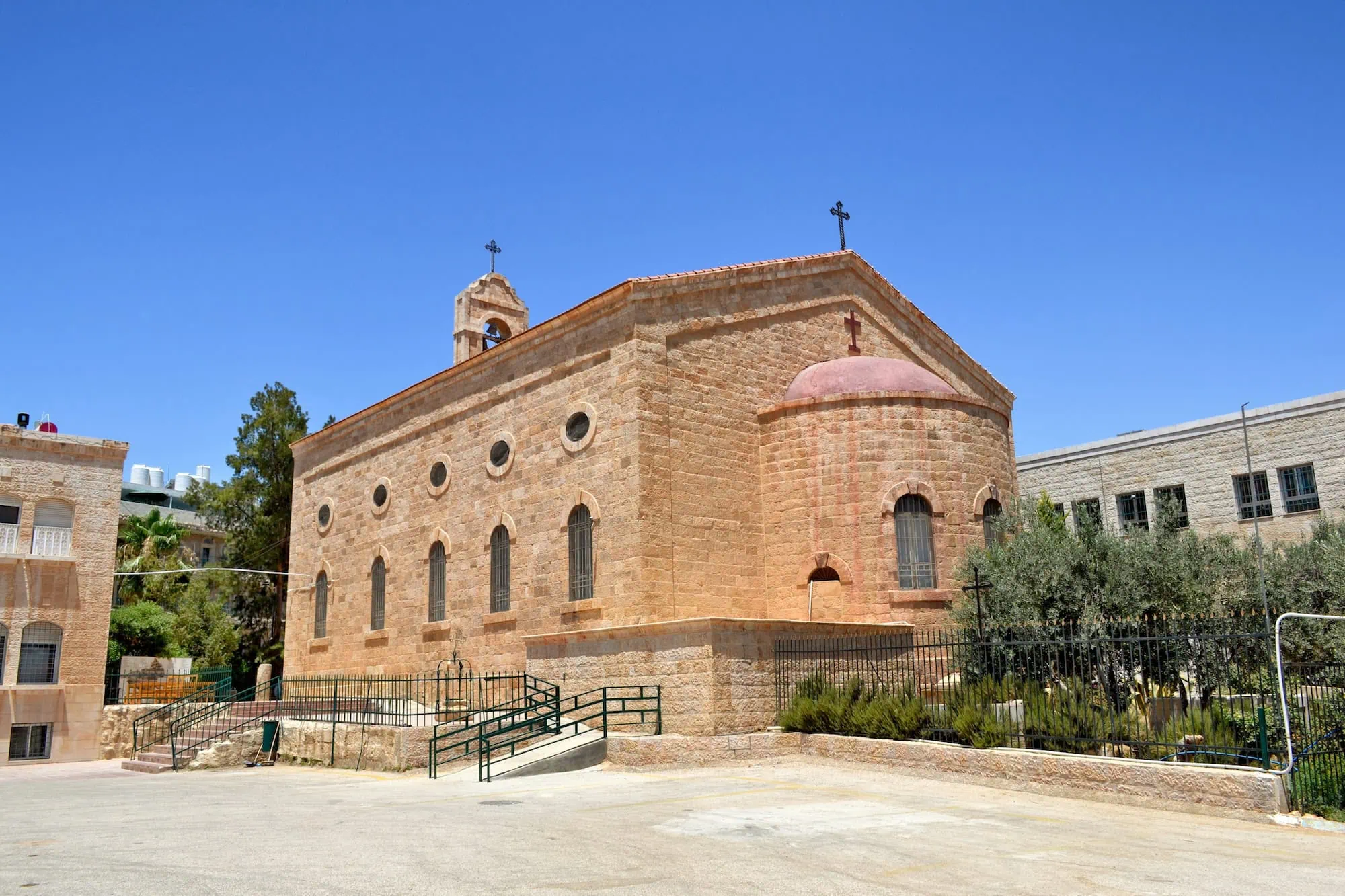 Saint George Greek Orthodox Church in Madaba, Jordan with pink dome and stone architecture