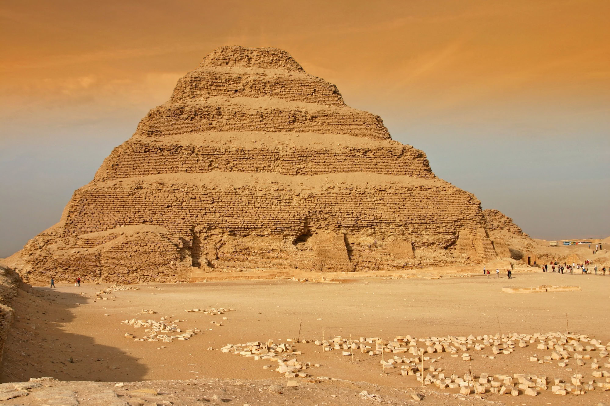 Small groups of tourists exploring the Step Pyramid of Djoser at Saqqara with professional guides
