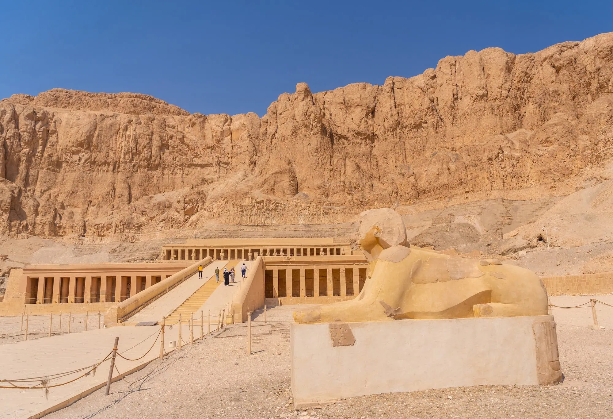 Rock-cut Temple of Hatshepsut with sphinx statue and limestone cliffs in Luxor, Egypt