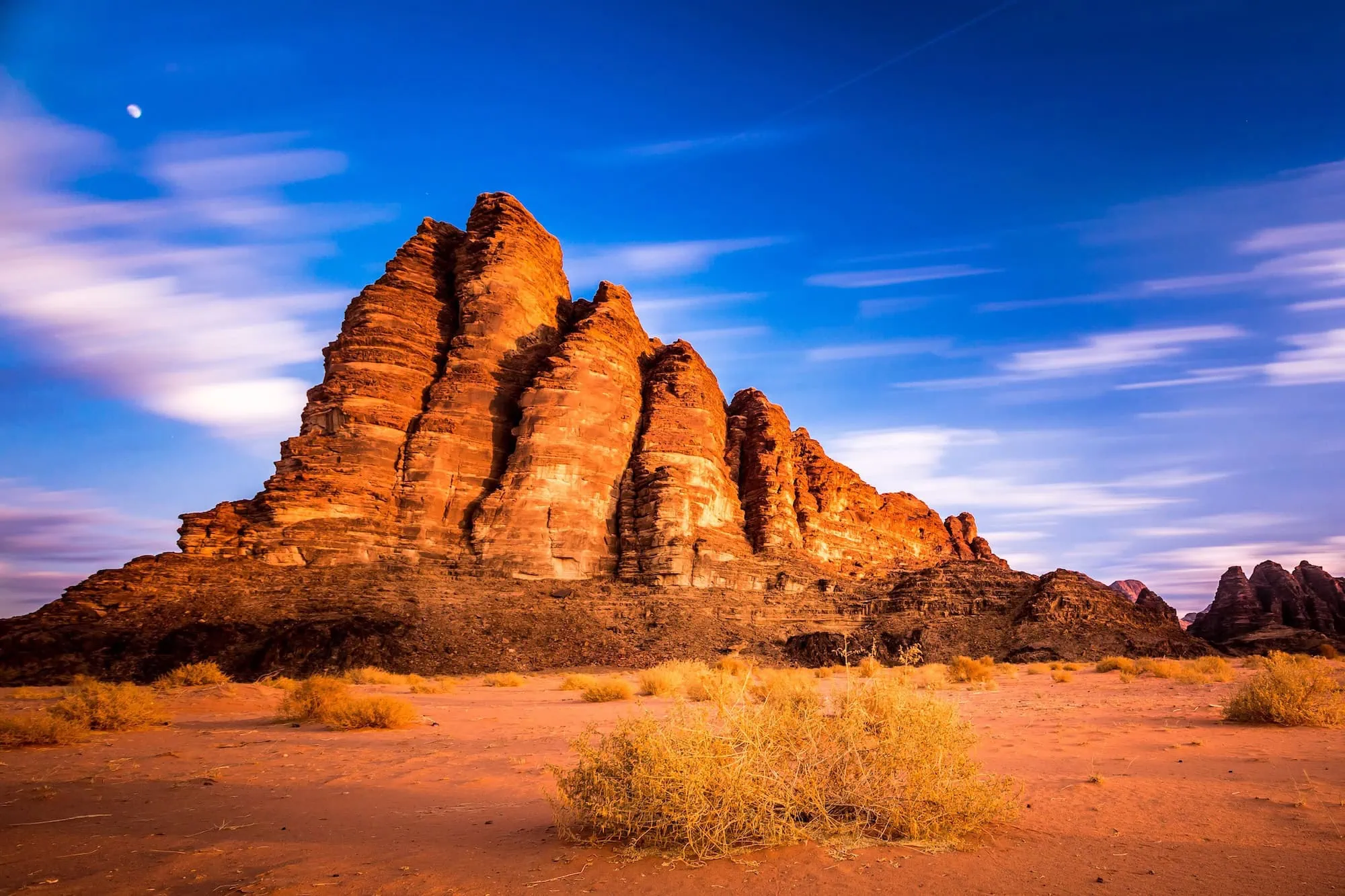 Paisaje marciano del desierto de Wadi Rum con formaciones rocosas y la luna