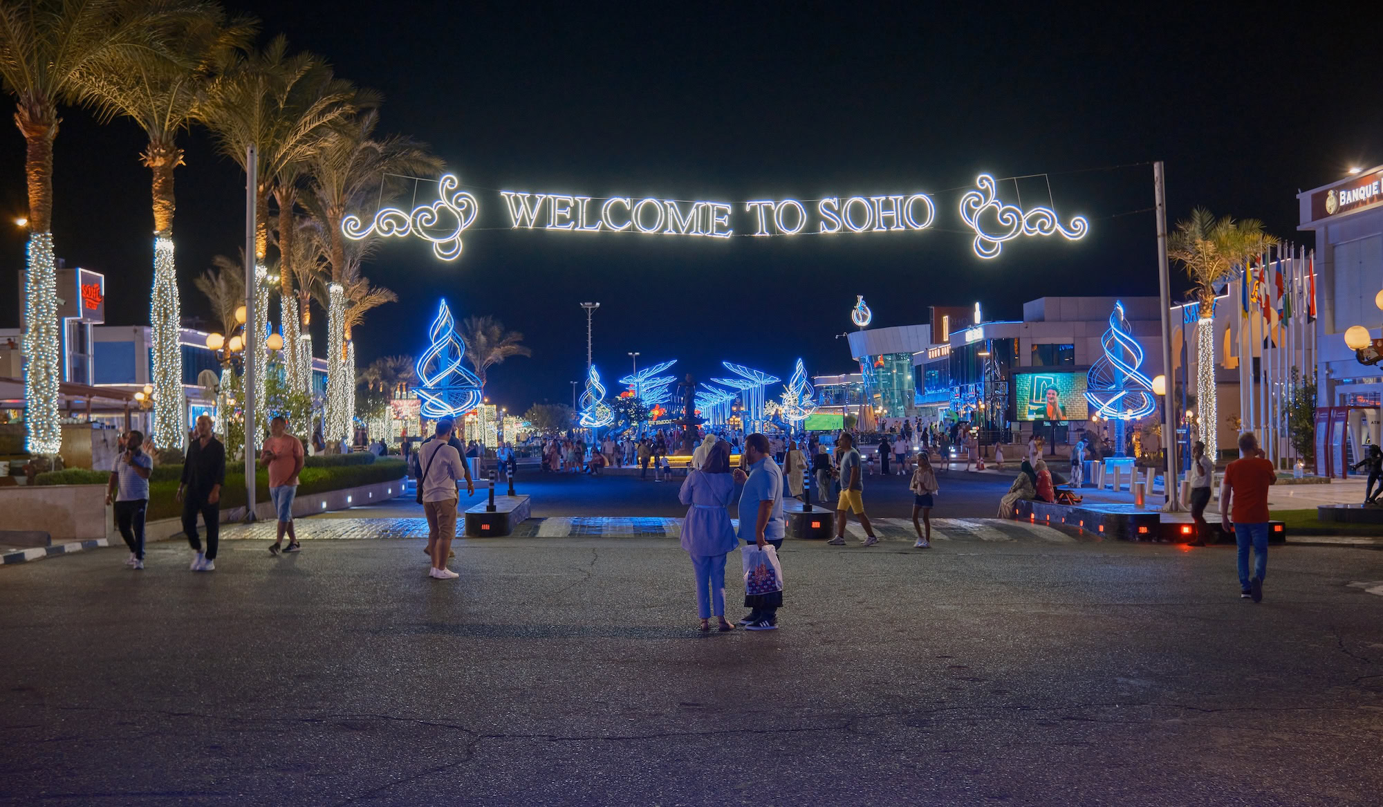 Vibrant nighttime view of Soho Square in Egypt with palm trees and decorative lighting