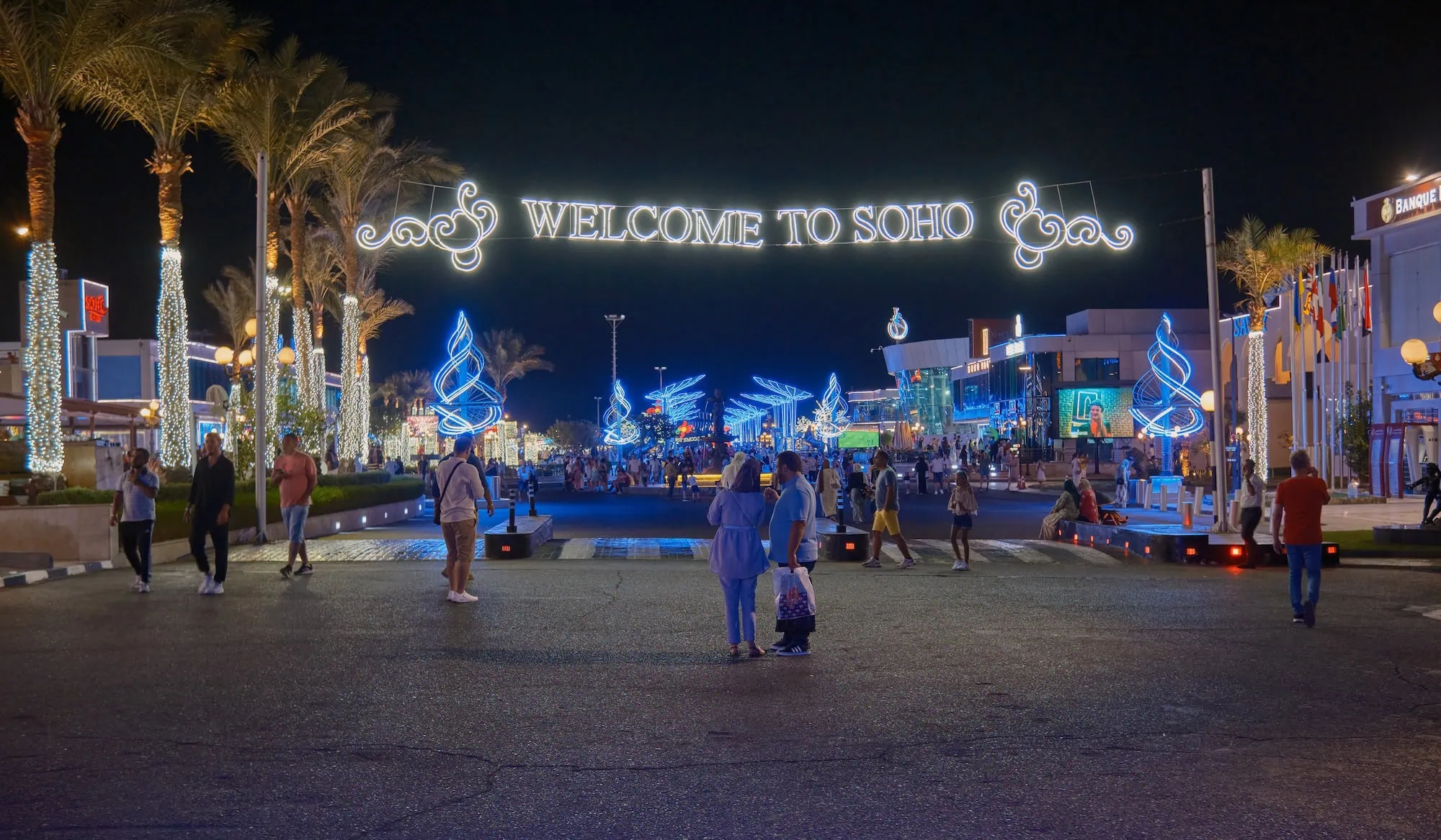 Vibrant nighttime view of Soho Square in Egypt with palm trees and decorative lighting