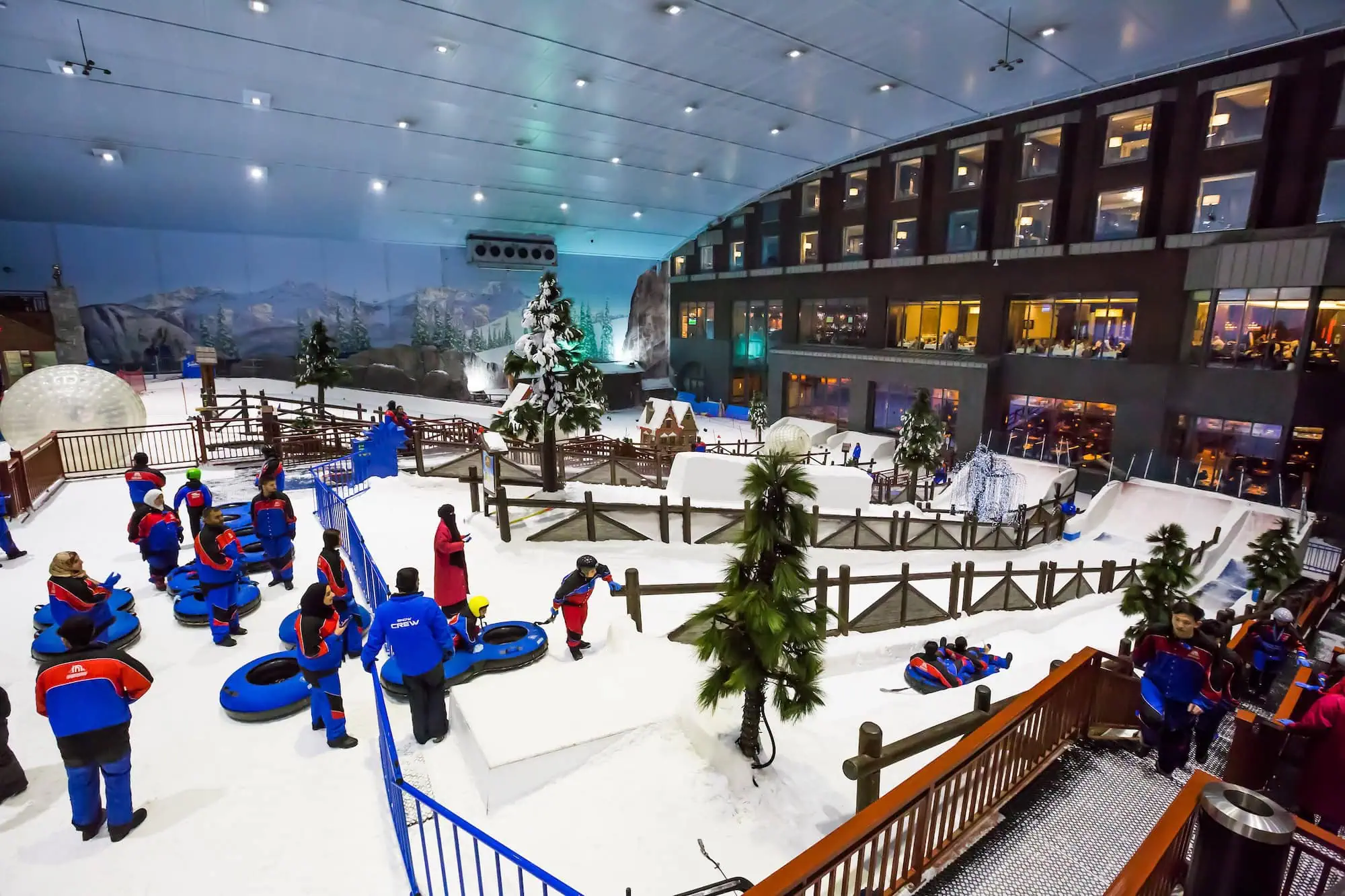 Interior view of Ski Dubai indoor ski resort with people enjoying winter activities on artificial snow