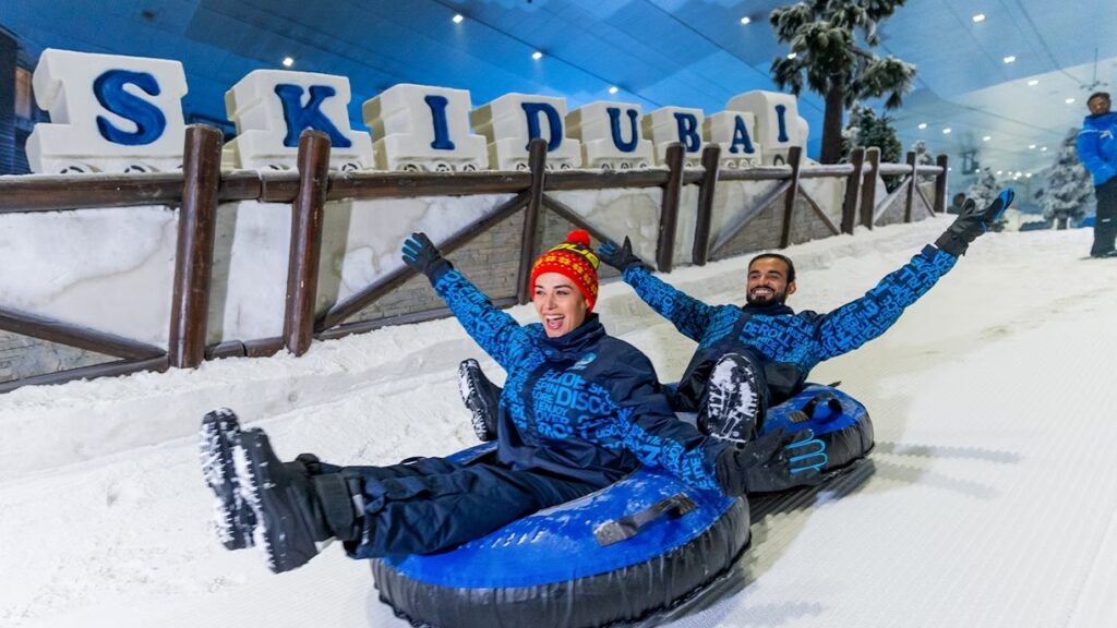Sledders gliding down snowy indoor slope at Ski Dubai