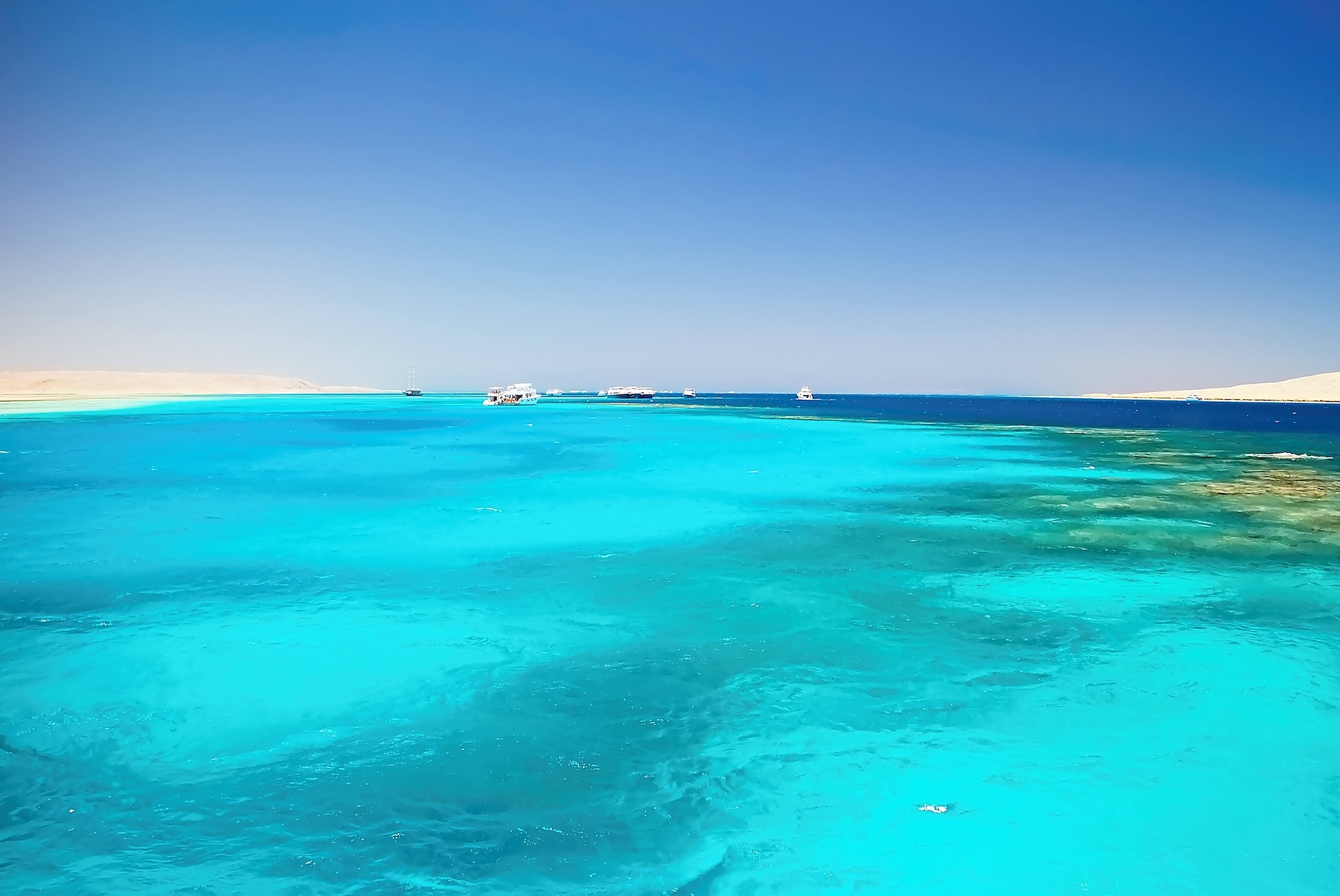 Crystal clear turquoise waters at Giftun Island showing colorful coral reef beneath the surface