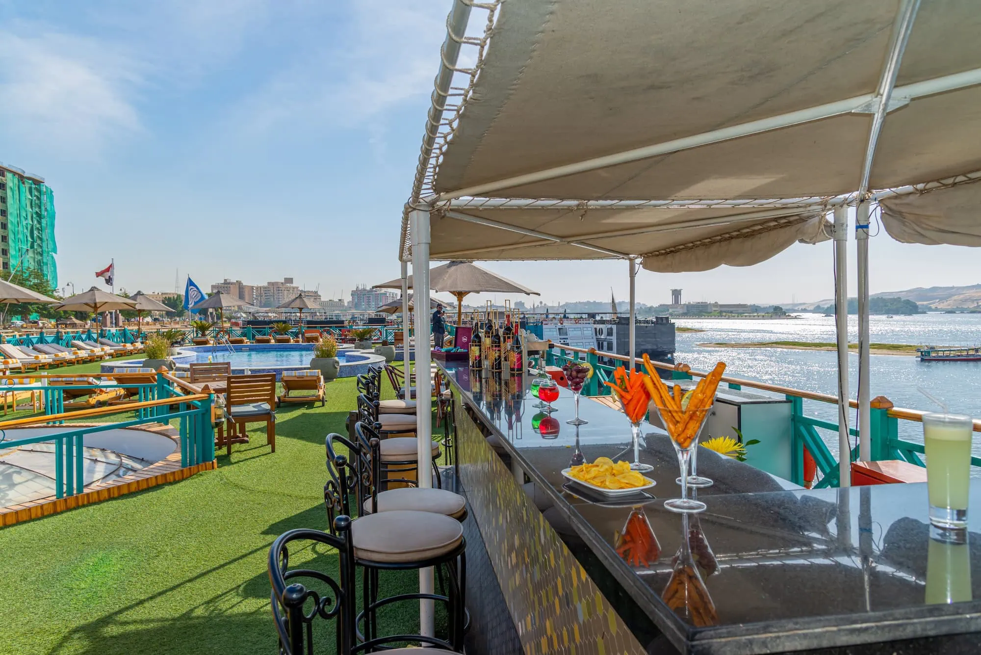 Luxury Nile cruise ship deck featuring swimming pool, bar, and elegant lounge seating