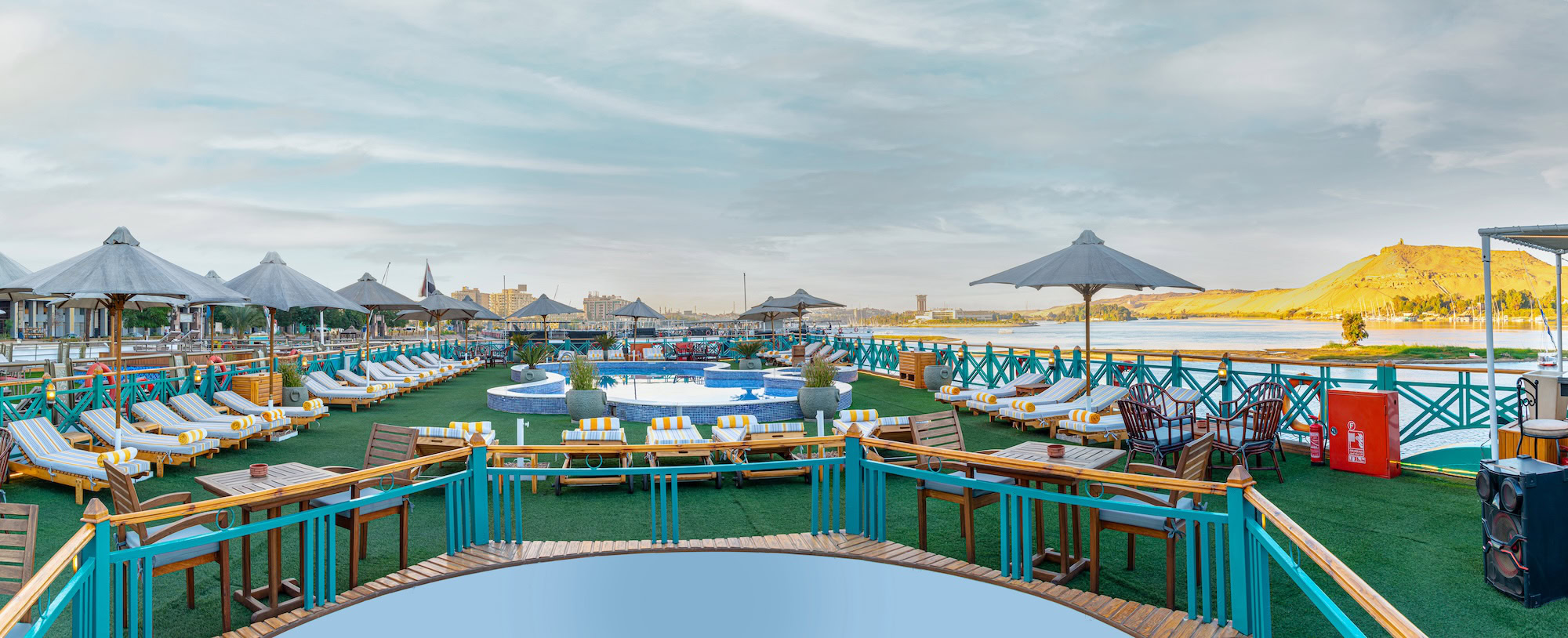 Luxurious Nile cruise ship deck with swimming pool, sun loungers, and umbrellas