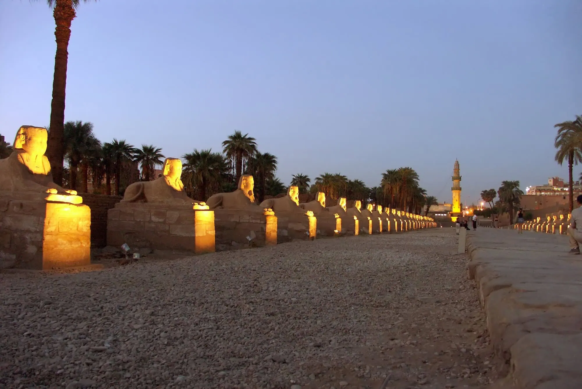 A Avenida das Esfinges restaurada em Luxor com caminho iluminado e estátuas de esfinges com cabeça de carneiro