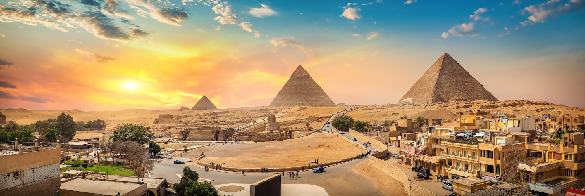 Great Pyramids of Giza and Sphinx in desert landscape with buildings and roads