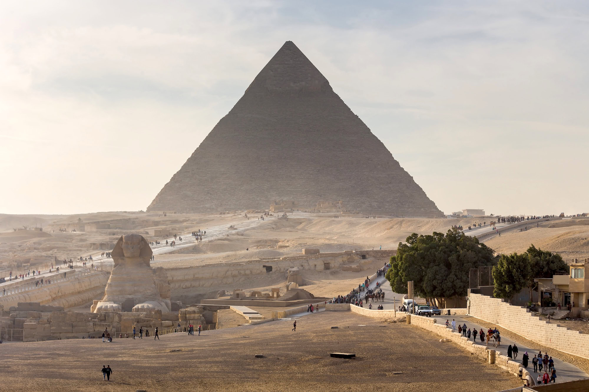 Turistas visitando as Pirâmides de Gizé e a Grande Esfinge no deserto egípcio