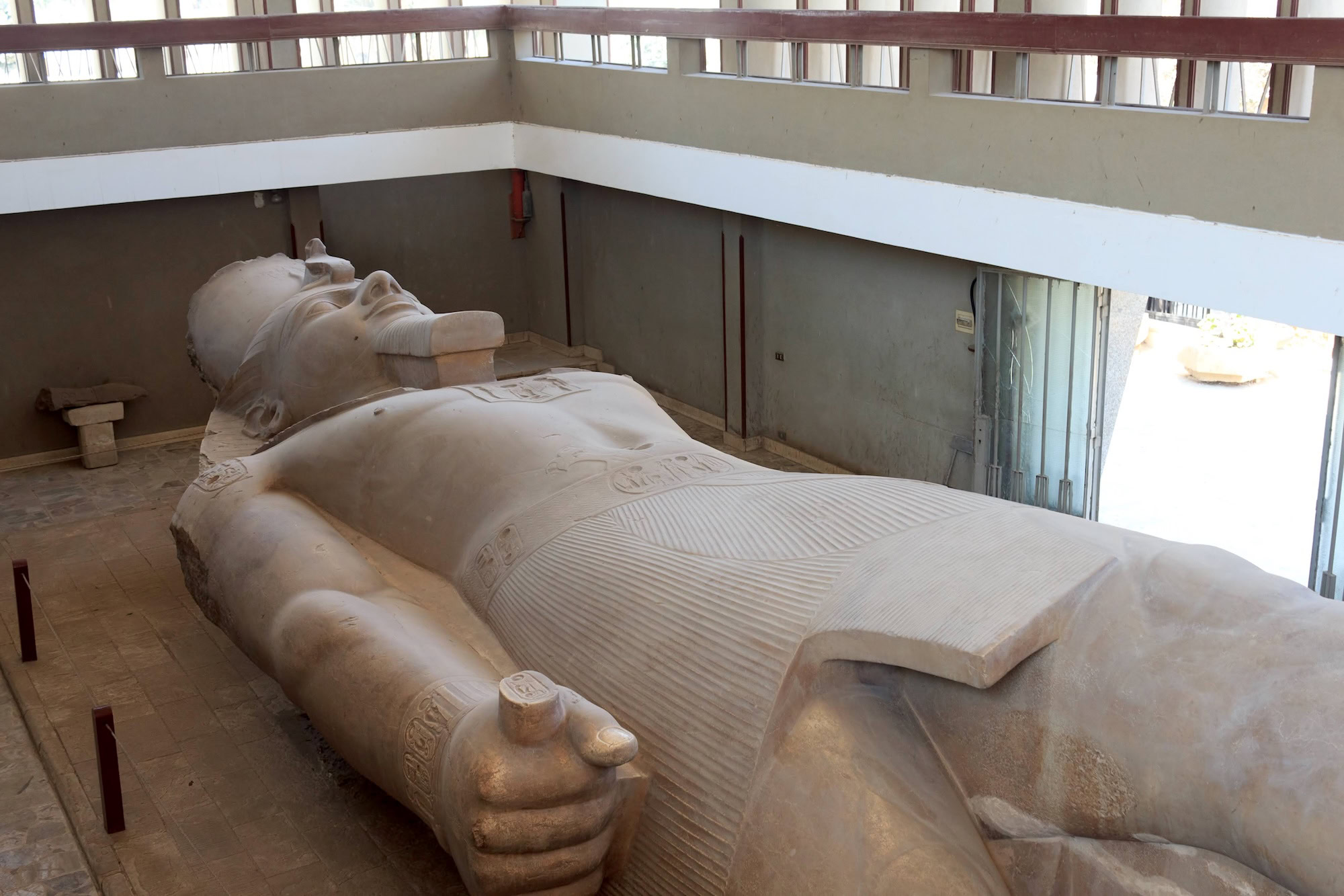 Ramses II statue at Memphis archaeological site with protective shelter