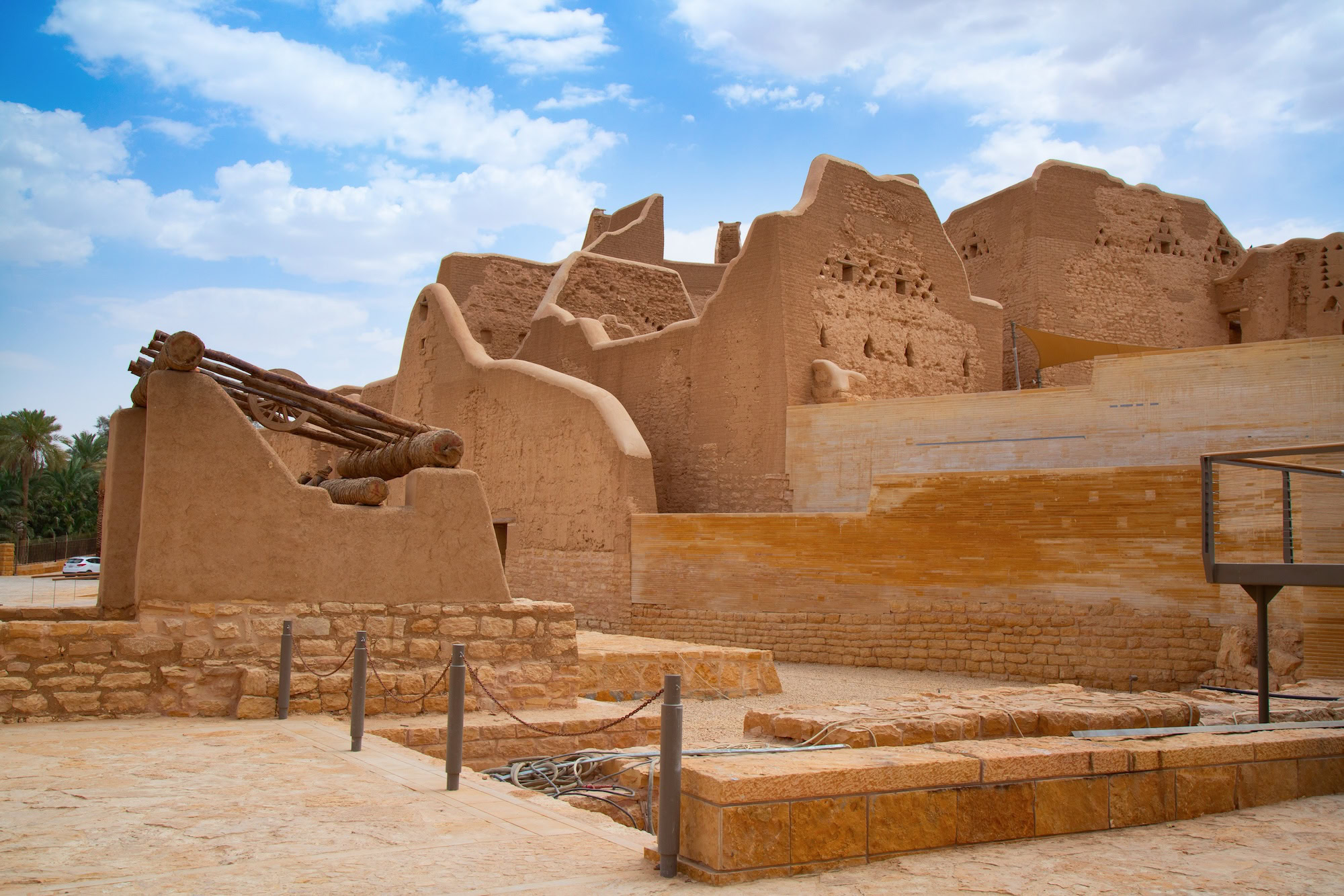 Traditional mud brick buildings in historic Diriyah district with palm trees