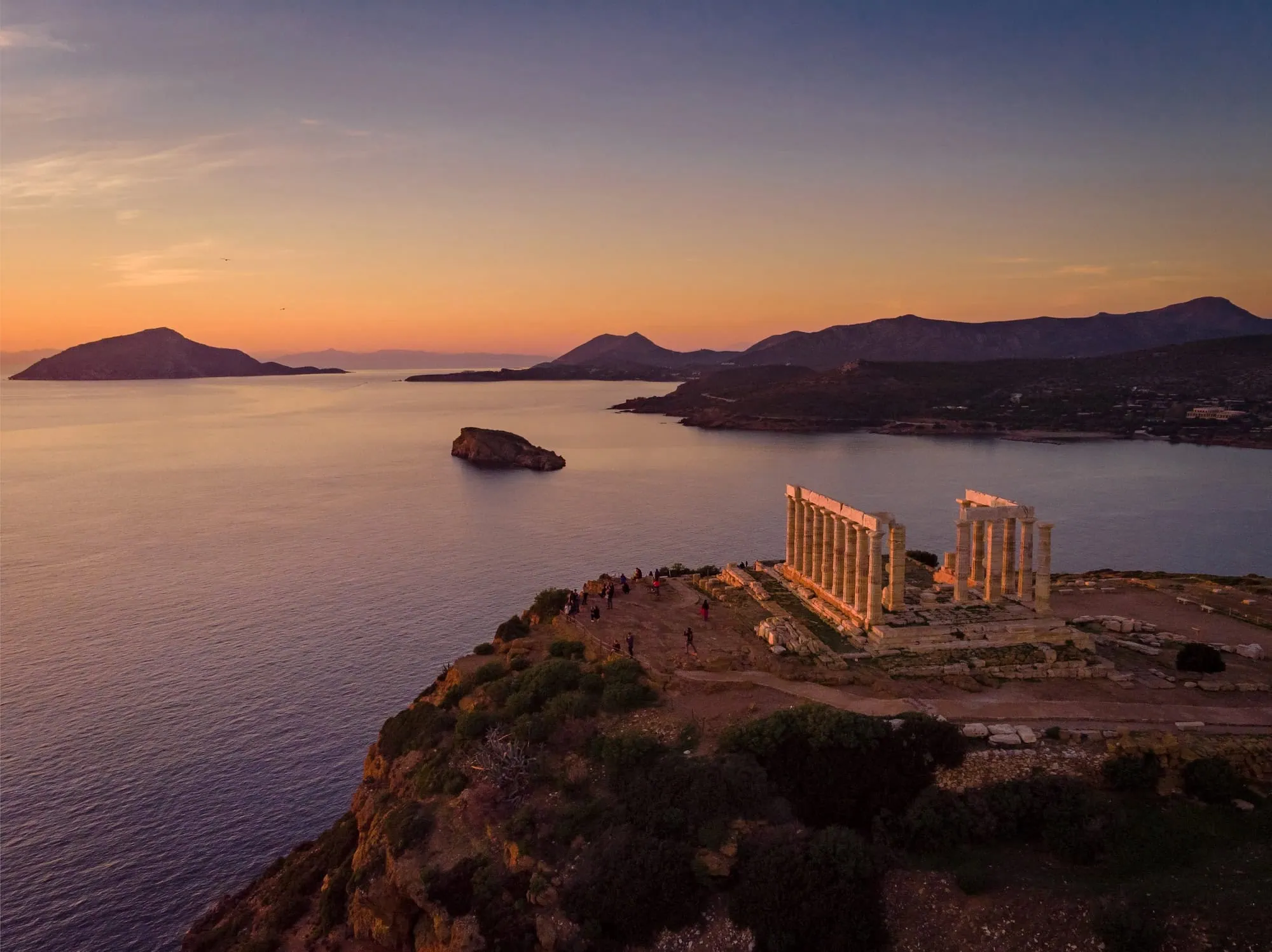 Ancient Temple of Poseidon ruins at sunset overlooking the Aegean Sea at Cape Sounio