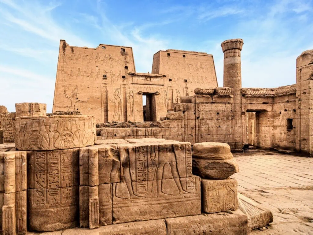 Temple of Horus with monumental pylon entrance and stone walls covered in carved reliefs, Edfu