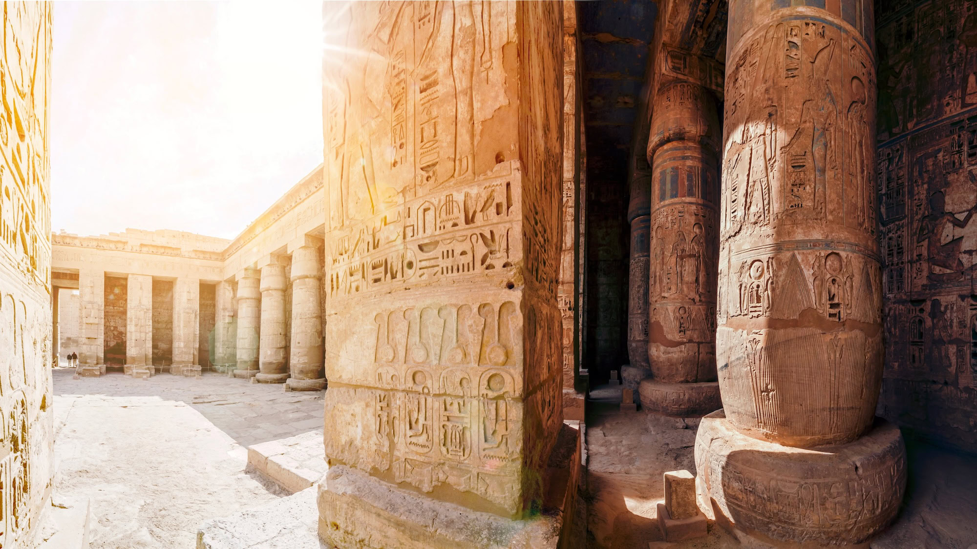 Ancient Egyptian temple walls with hieroglyphic carvings and columns