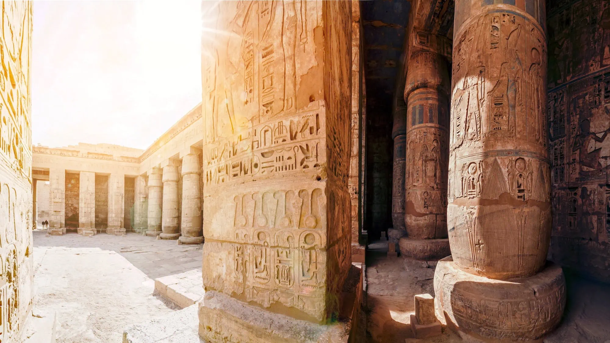 Ancient Egyptian temple walls with hieroglyphic carvings and columns
