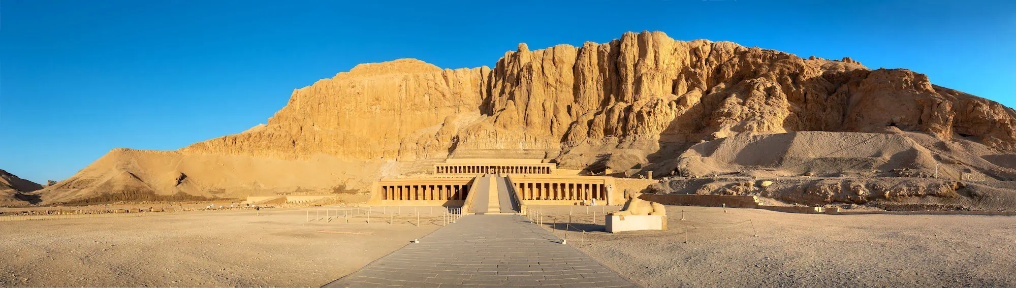 Temple of Hatshepsut with terraced structure against dramatic desert cliffs
