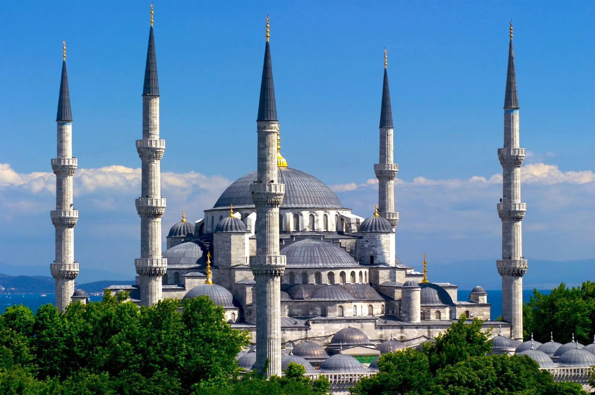 Majestic Blue Mosque with six minarets and cascading domes against cloudy sky
