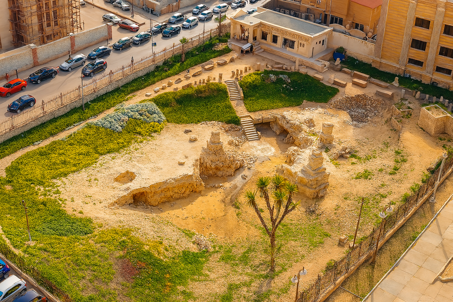 Aerial view of archaeological excavation site with systematic grid layout and exposed stone foundations