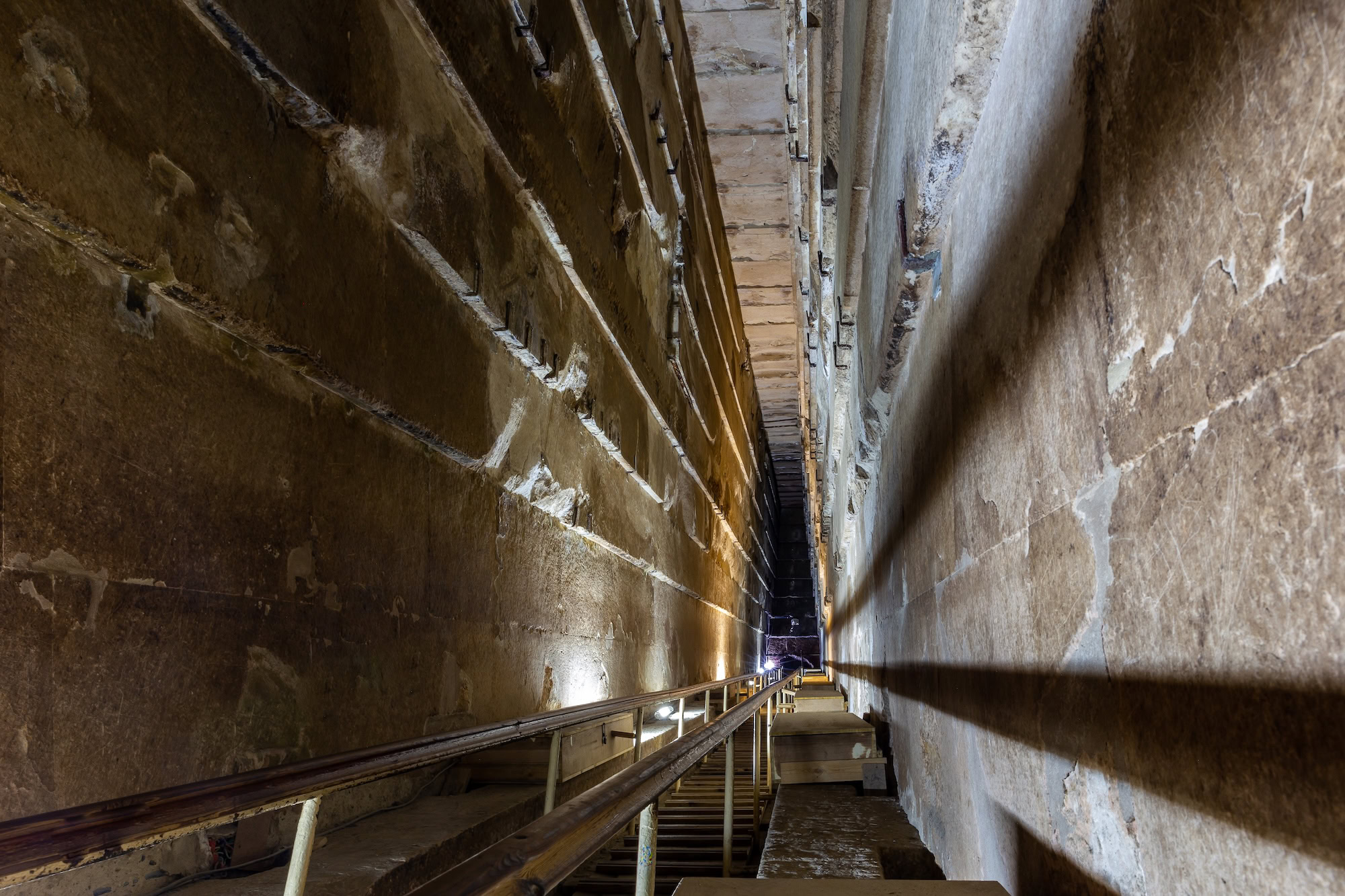 Interior view of the Grand Gallery inside the Great Pyramid of Giza showing ancient stone corridor with modern walkways