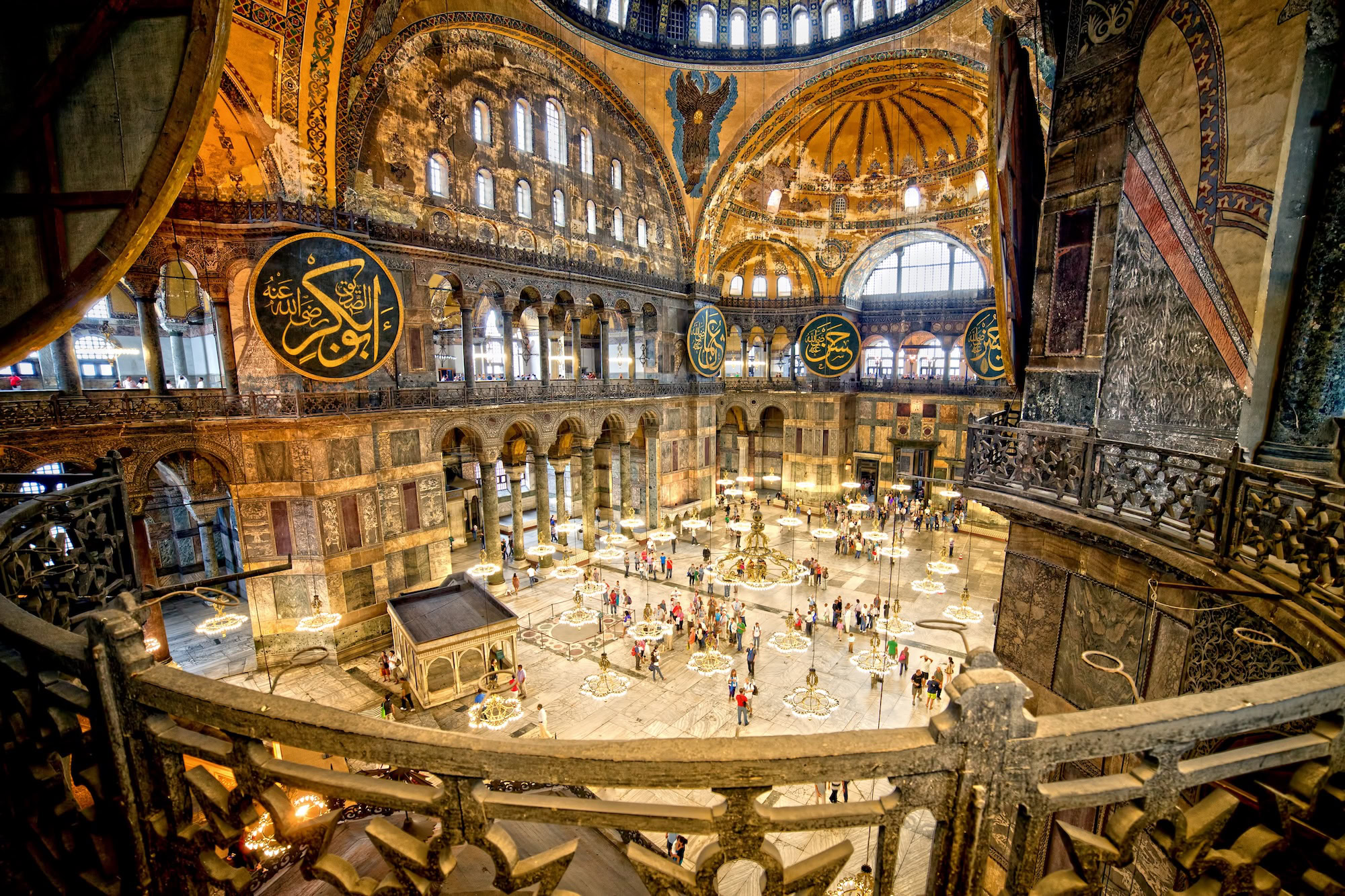 Interior of Hagia Sophia showing restored dome, columns, and Islamic calligraphy