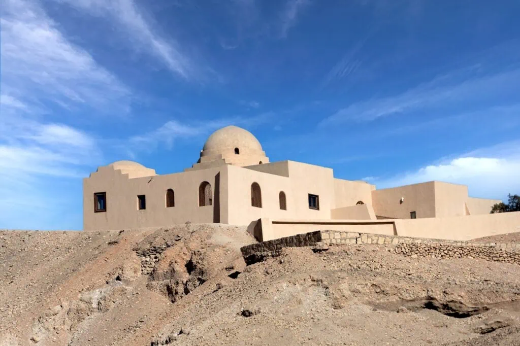 Exterior view of the Howard Carter House with simple stone architecture set within the Theban Necropolis landscape, Luxor