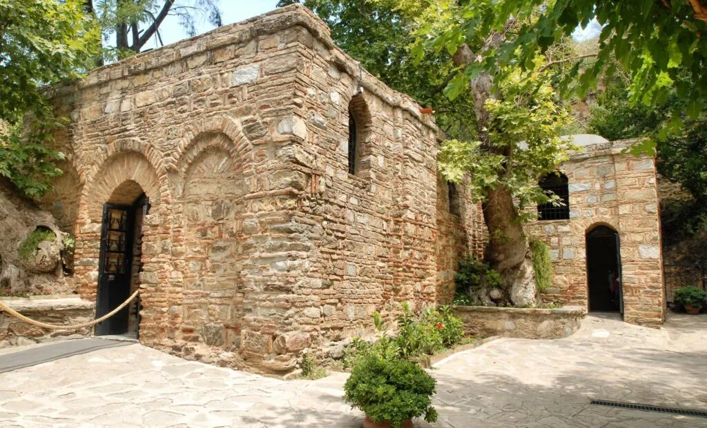 House of the Virgin Mary stone building with arched entrance and surrounding trees, Selcuk