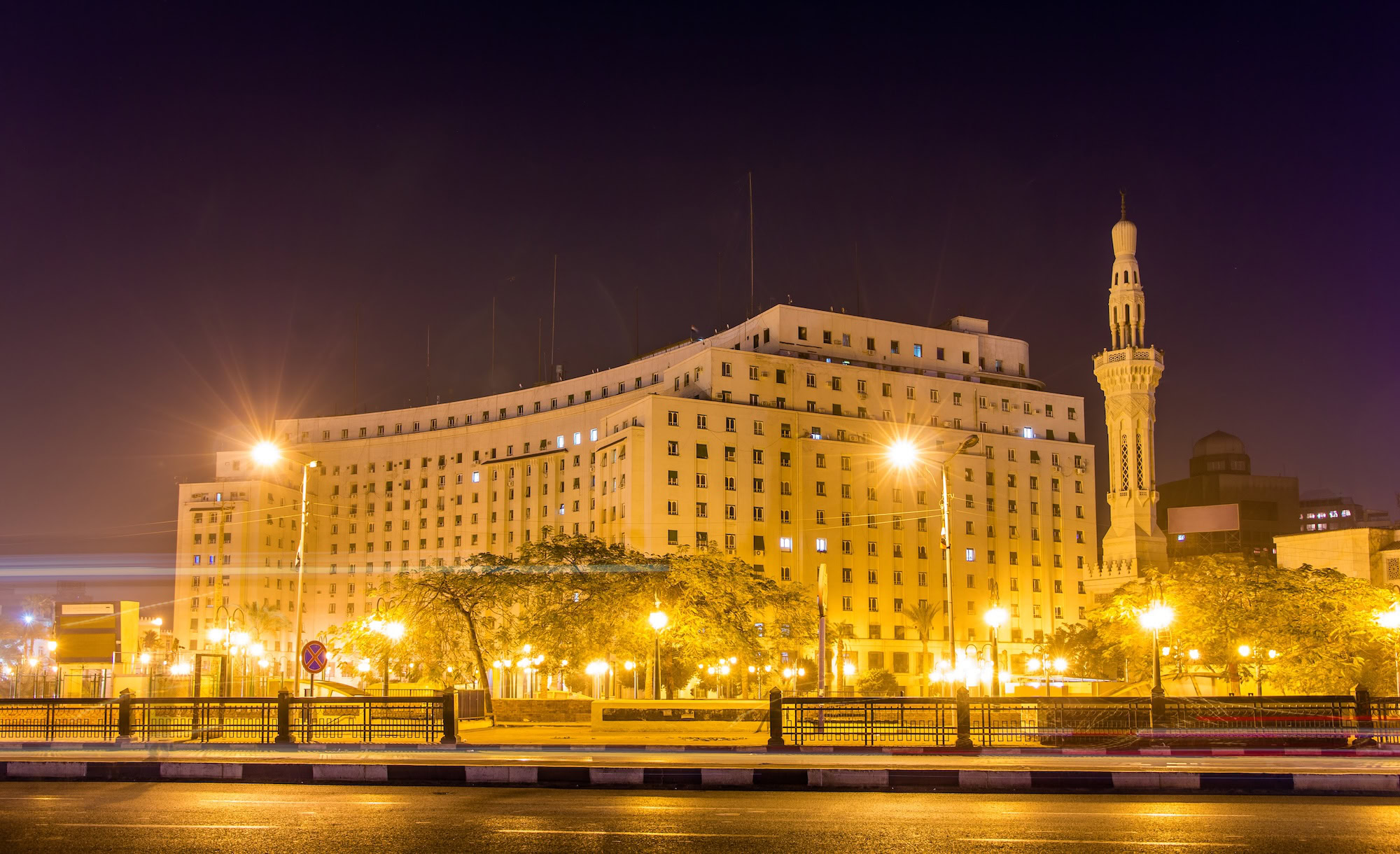 Nighttime view of Tahrir Square in Cairo with illuminated government buildings and minaret