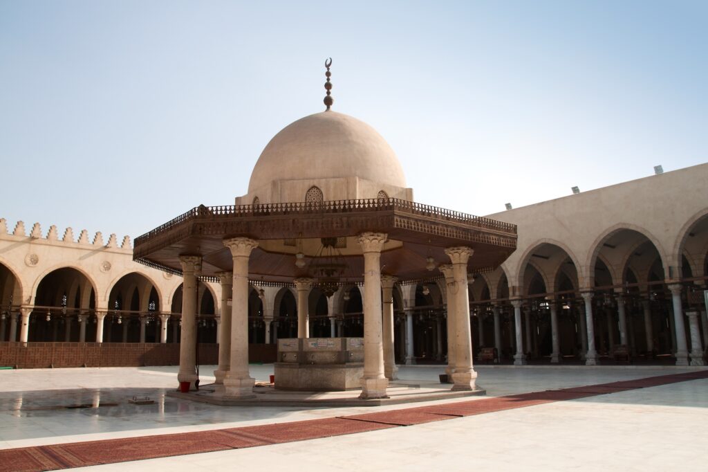 The central courtyard fountain with marble columns, wooden canopy, and surrounding arcades at the Mosque of Amr ibn al-As, Cairo