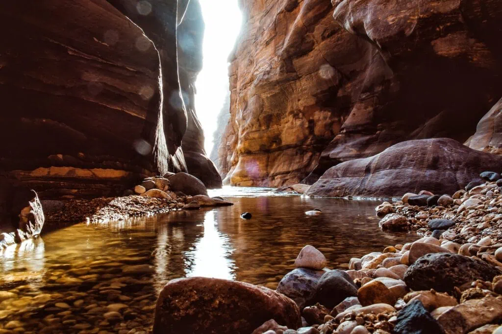Mujib Biosphere Reserve canyon with steep sandstone cliffs and a river flowing through the gorge, Wadi Mujib