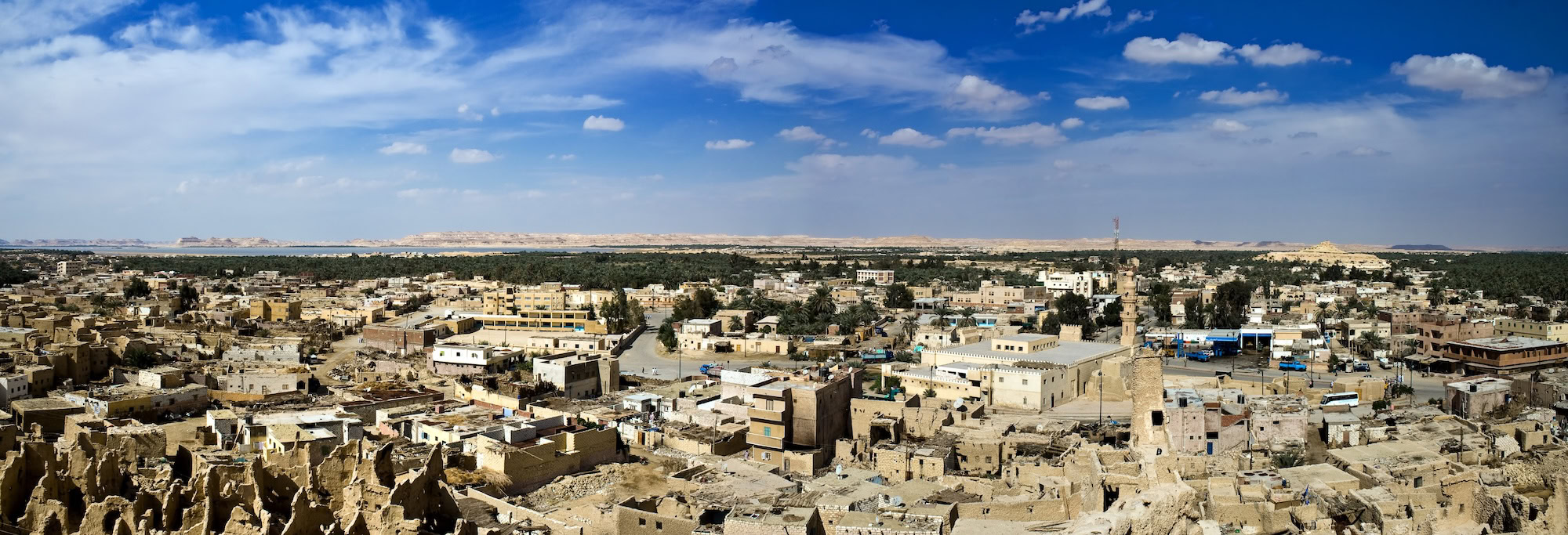Vista panorâmica do Oásis de Siuá com arquitetura tradicional e palmeiras no deserto