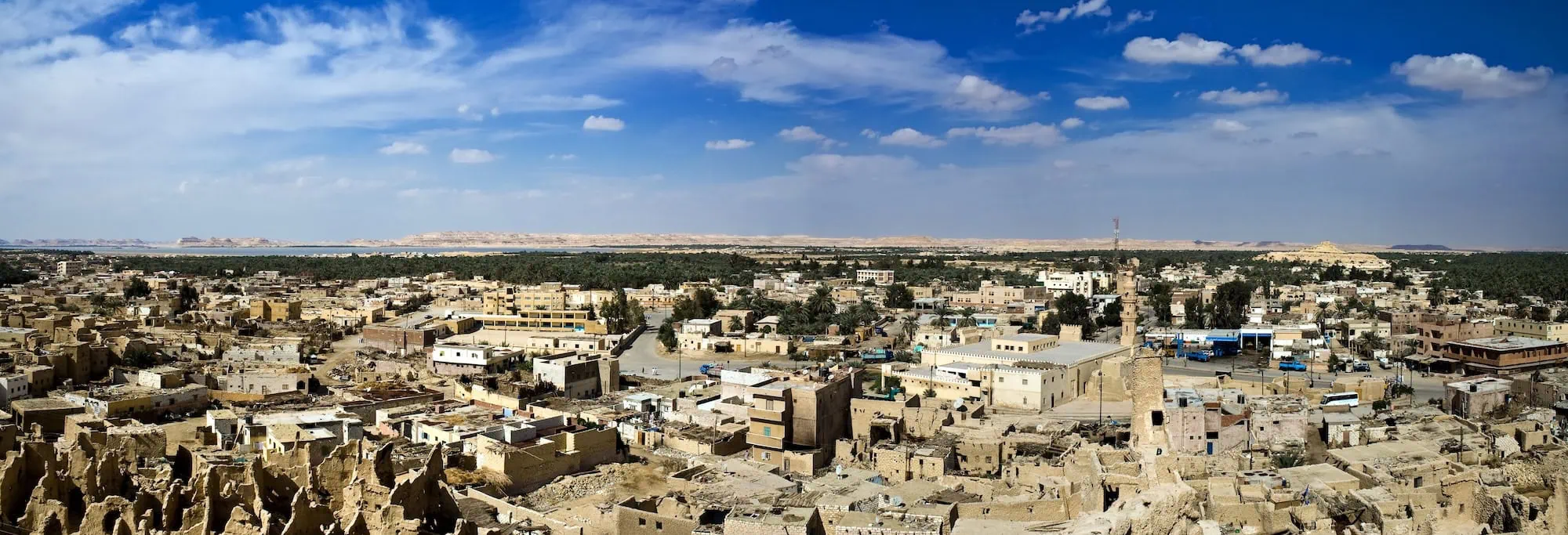 Vista panorâmica do Oásis de Siuá com arquitetura tradicional e palmeiras no deserto