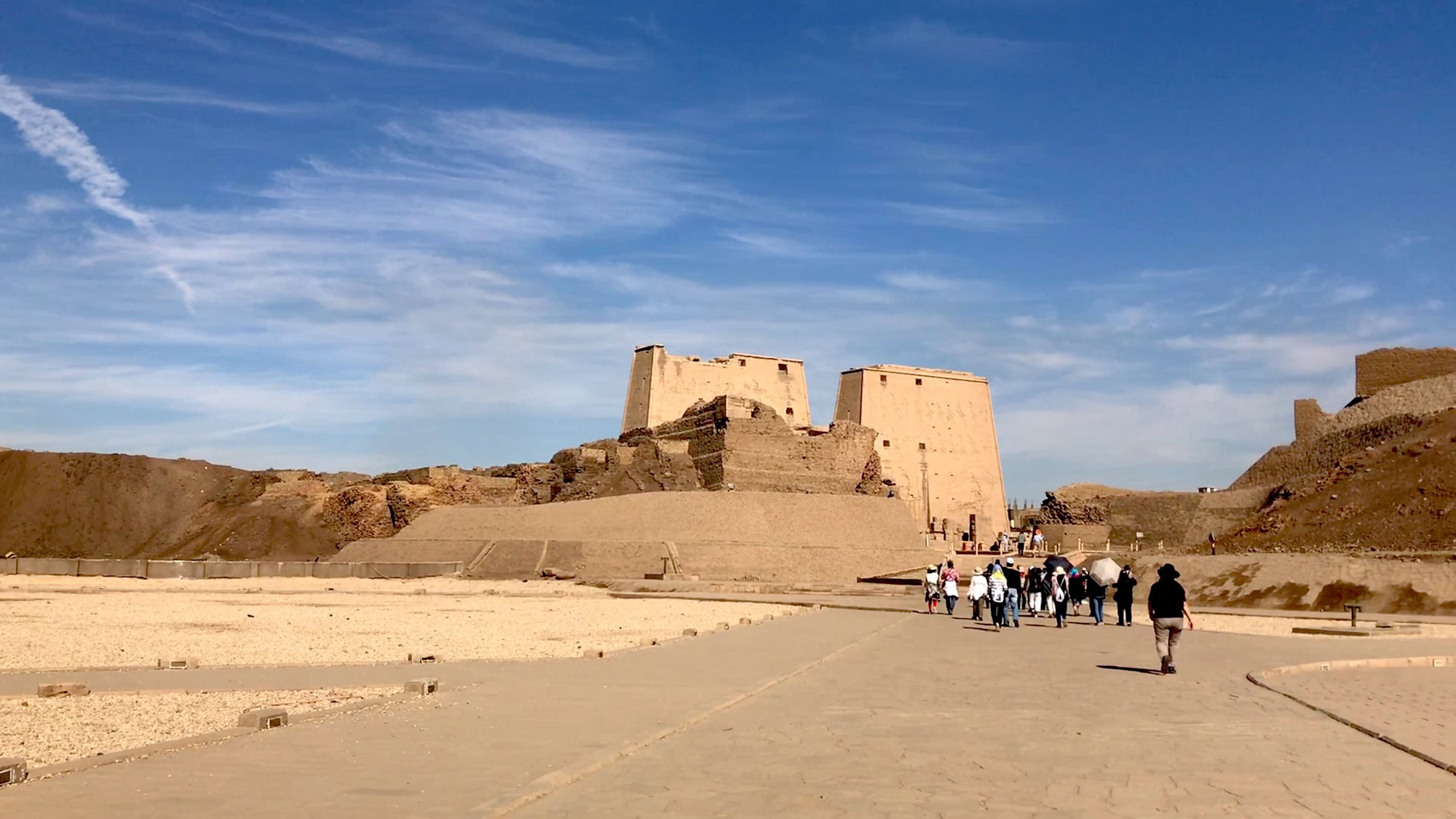Ancient Egyptian Temple of Edfu with stone columns and tourists in courtyard